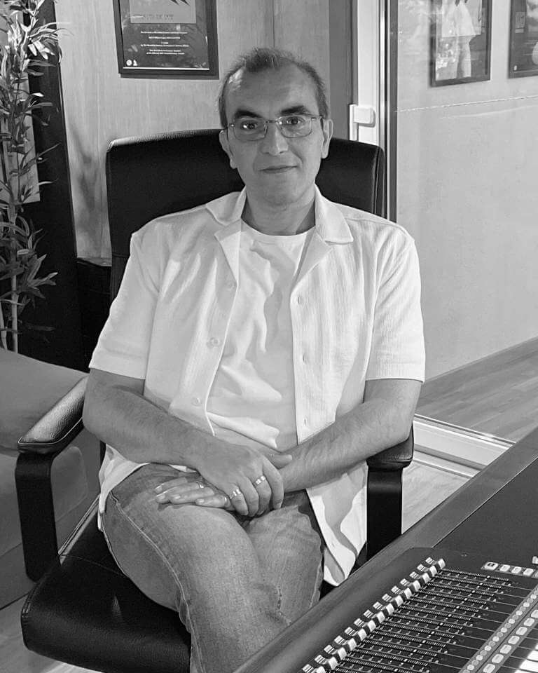 Leopoldo Lopes, founder of Sound Pressure Studios, seated in the control room surrounded by professional audio equipment and studio decor.