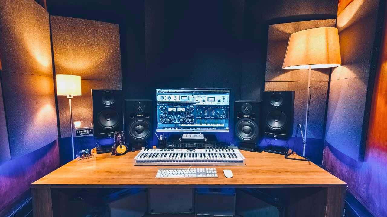 Professional music production setup with dual monitor speakers, a keyboard controller, and a well-lit workstation.